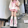 A pair of pink and white Gothic Lolita heart bow leg warmers displayed on a staircase.