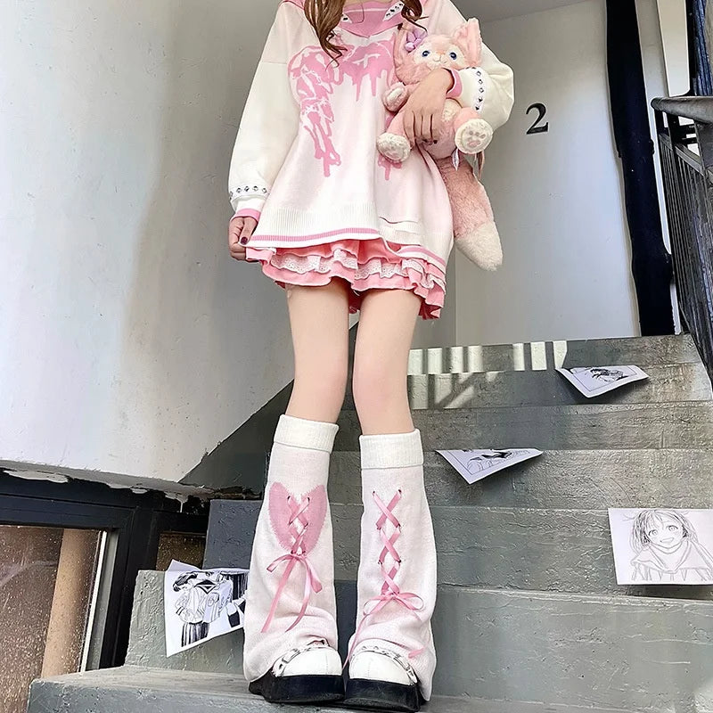 A pair of pink and white Gothic Lolita heart bow leg warmers displayed on a staircase.