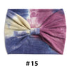 Un bandeau en coton tie-dye violet et bleu noué en nœud.