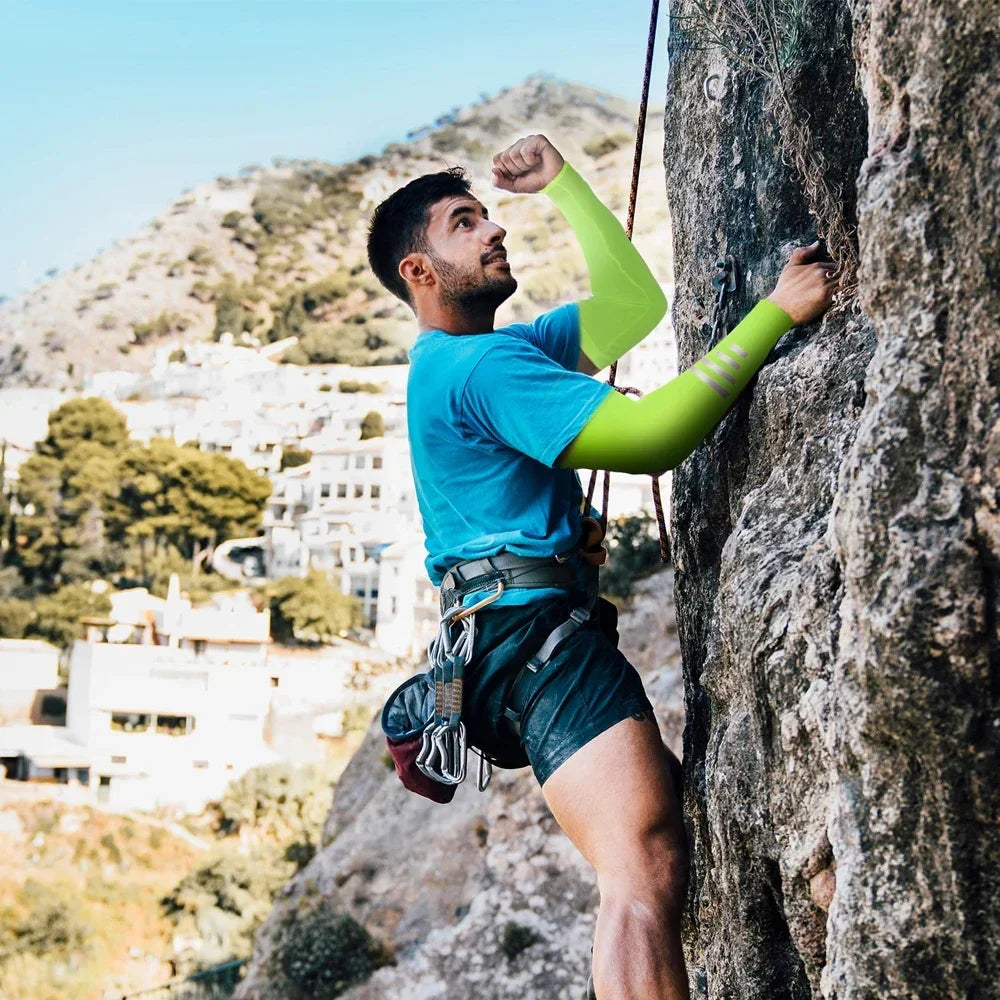 Ein Mann mit leuchtend grünen UV-Schutz-Cooling-Ärmeln klettert eine felsige Klippe im Freien.