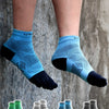 A pair of blue compression socks worn on legs, with several other colored five-finger socks displayed below.