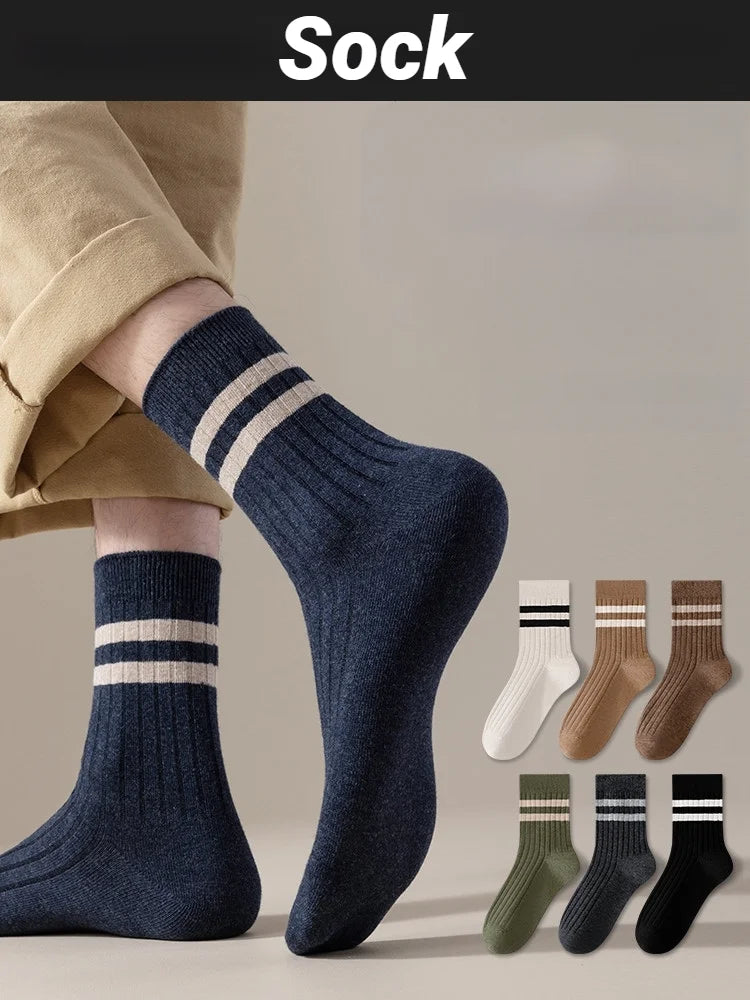 A close-up of navy blue striped socks worn on a foot, with several additional pairs displayed below.