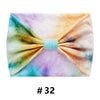Bandeau en coton tie-dye noué en nœud avec des tons de violet, jaune et bleu.