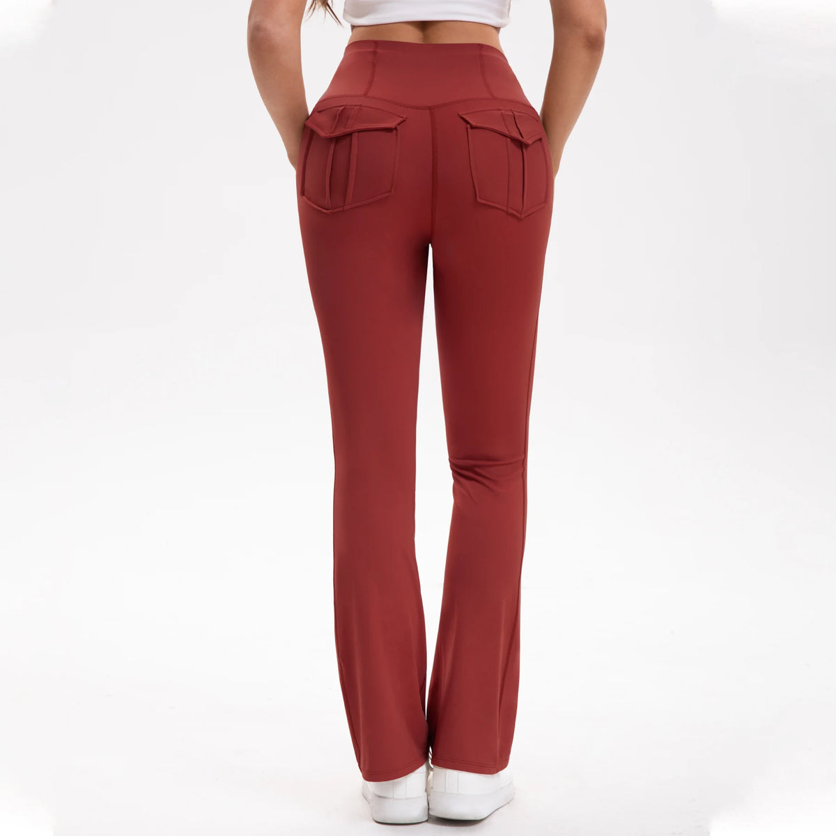 A model wearing maroon high-waisted flared yoga leggings with patch pockets.