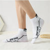 A pair of white men's breathable mesh performance socks with black stitching and the word SPORTSMAN visible on the foot.