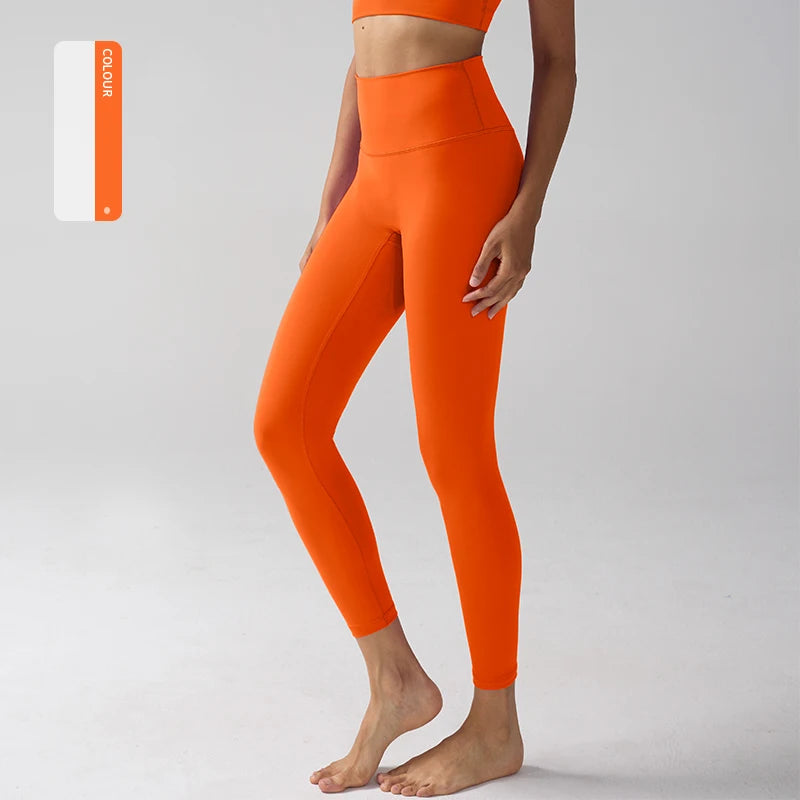 Un modèle portant des leggings de performance orange vif à taille haute.