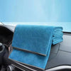 A stack of blue microfiber car cleaning towels resting on a car interior surface.