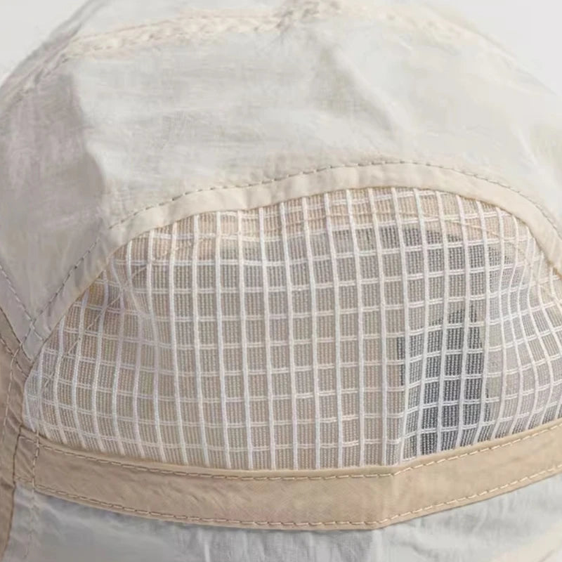 A close-up of a white breathable quick-dry baseball cap with a sheer mesh panel on the front.