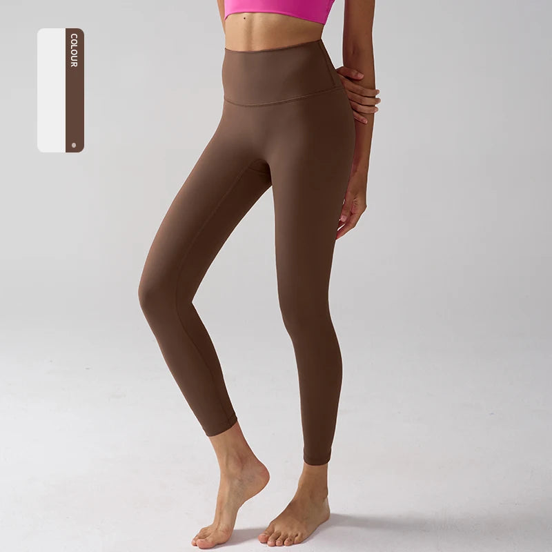 Un mannequin porte des leggings de performance taille haute de couleur marron.