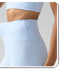 Une femme porte des leggings de performance bleu clair taille haute, de la taille vers le bas.