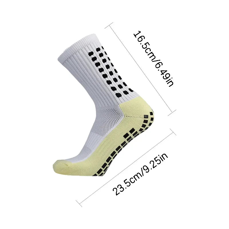 A pair of white football training socks with black dots and a yellow shin guard, shown from the side.