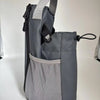 A gray magnetic water bottle bag designed to hold keys and a phone, shown from the side.