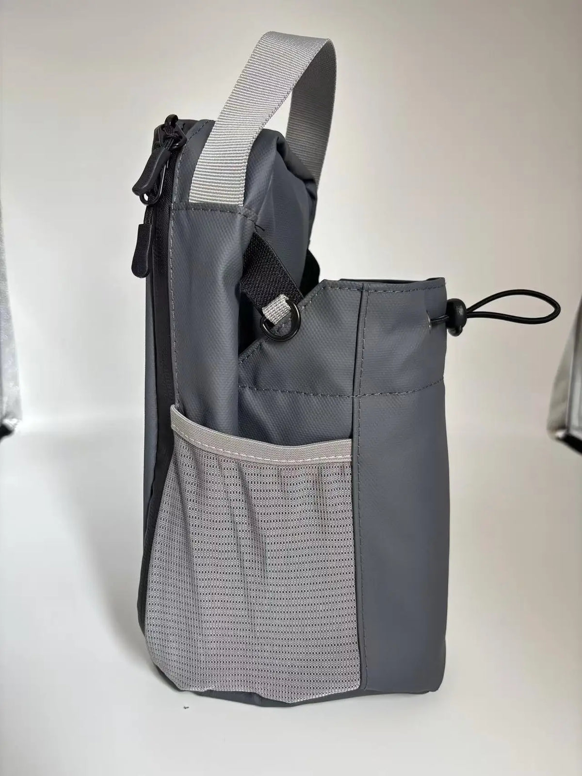 A gray magnetic water bottle bag designed to hold keys and a phone, shown from the side.