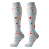 A pair of white knee-high compression socks decorated with small orange, red, and blue patterns.