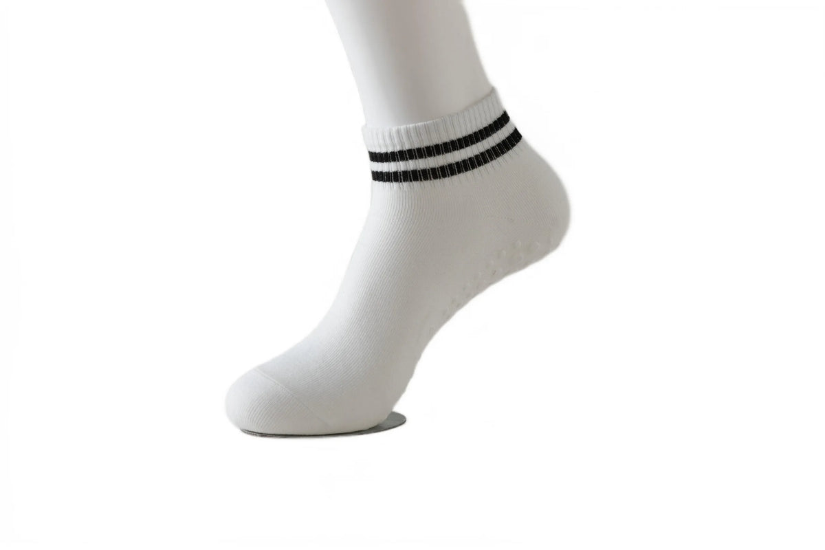 White sock with black stripes on the ankle, showing non-slip grip socks for yoga and pilates.