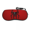 A red pouch with a black spider web design and a strap for storing eyeglasses.