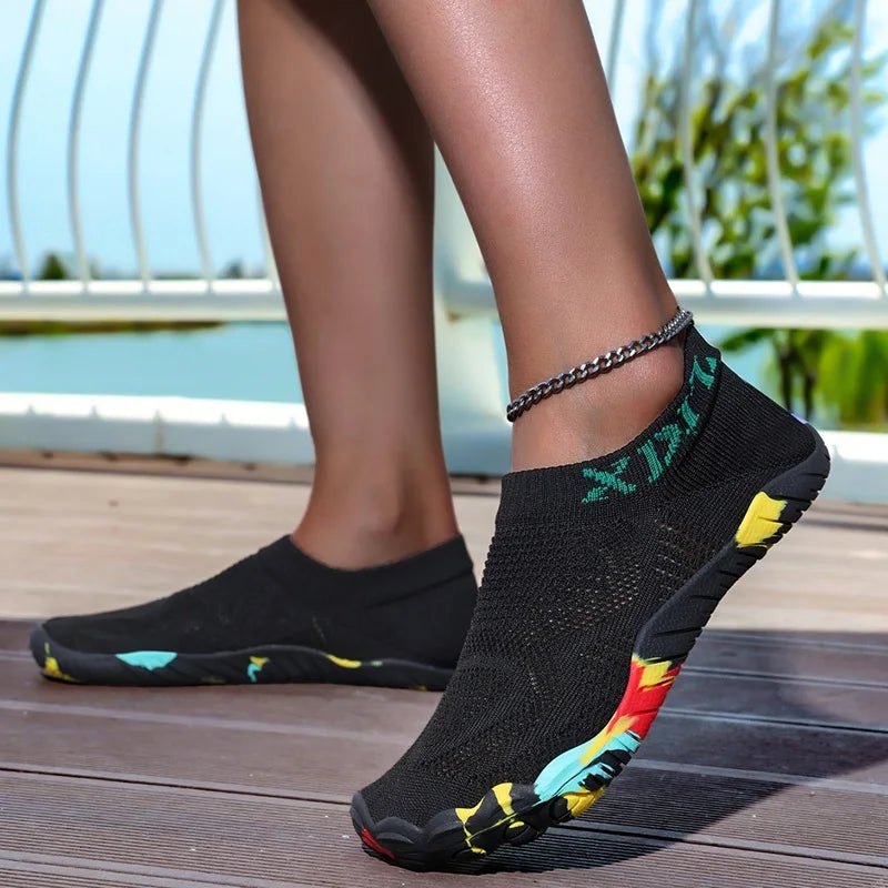 A close-up of black waterproof quick-dry outdoor hiking shoes worn by a person outdoors.