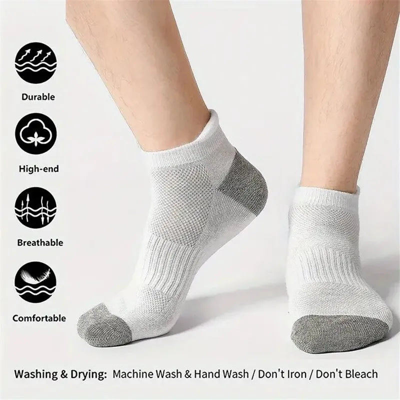 A pair of light gray men's cotton blend ankle socks shown on a person's foot.
