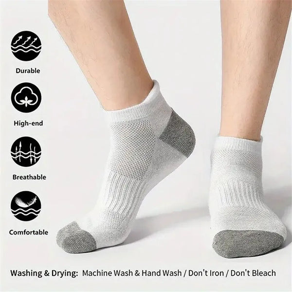 A pair of light gray men's cotton blend ankle socks shown on a person's foot.