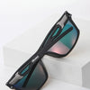 A pair of black polarized sports sunglasses with blue-green lenses resting on a white surface.