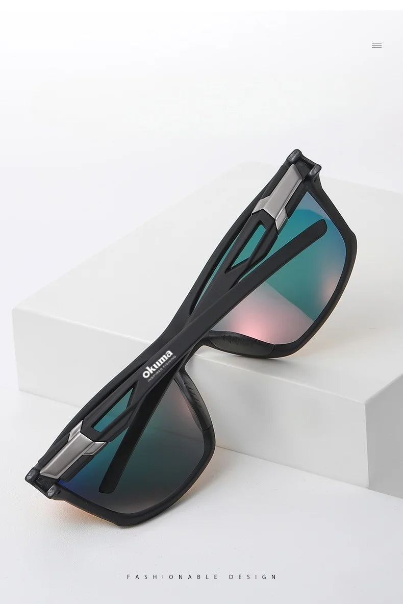 A pair of black polarized sports sunglasses with blue-green lenses resting on a white surface.
