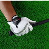 A hand wearing a white golf glove with black accents is holding a golf club on a green turf.
