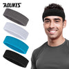 A man wearing a black moisture-wicking athletic headband, with various colored headbands displayed nearby.