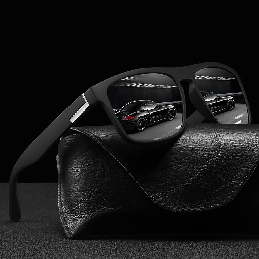 Vintage designer square sunglasses resting on a black leather surface with a blurred car in the background.