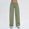 A full-length shot of olive green high-waist flared yoga pants being worn by a person.