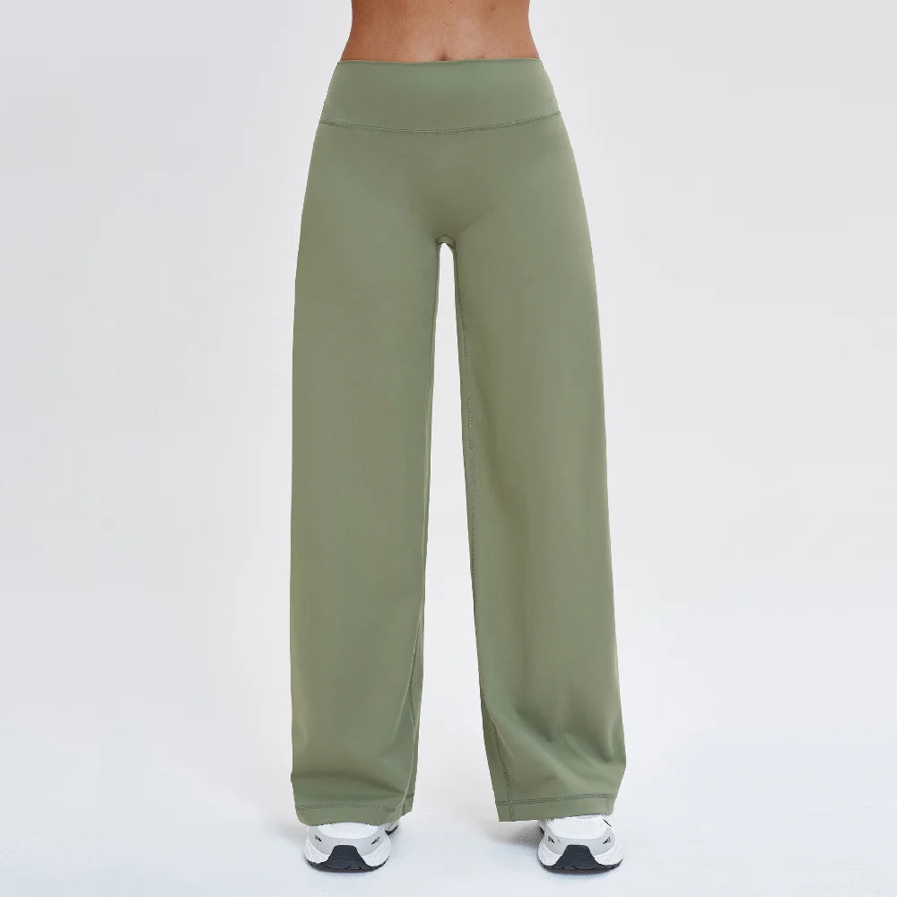 A full-length shot of olive green high-waist flared yoga pants being worn by a person.