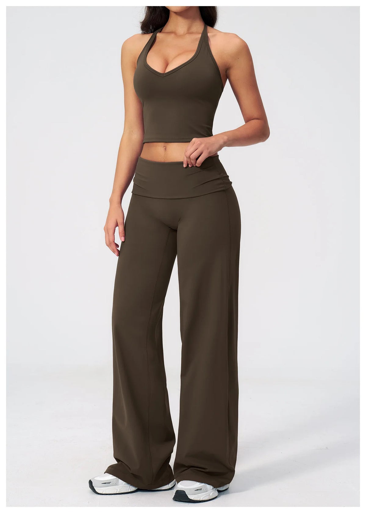 A woman models a pair of dark olive green flared high-waist yoga and fitness pants.