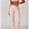 A woman models a pink 3-piece yoga sports set consisting of a cropped top, leggings, and a sports bra.