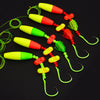 Five colorful catfish float rigs with rattler hooks arranged diagonally on a black background