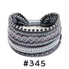 A patterned boho knotted cotton headband featuring geometric designs in shades of gray, black, and teal.