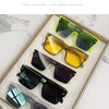 A display of various FENG pure titanium sunglasses in yellow, green, and black shades.