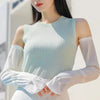 A woman models light blue ribbed UV protection arm sleeves on her arms.