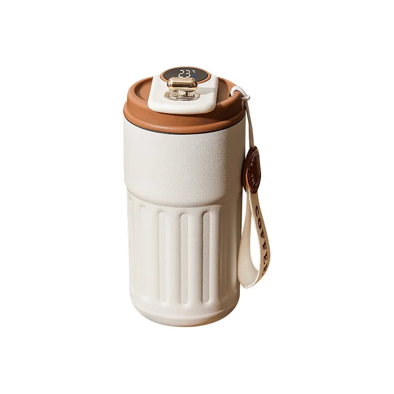 A white insulated thermos bottle with a brown lid and a leather strap attached.
