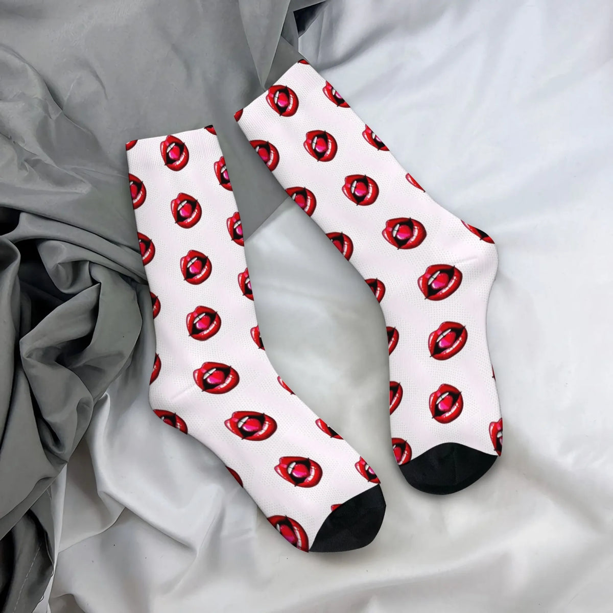 Pair of white mid-calf socks with a repeating pattern of red lip prints on a gray fabric background.