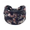 A black floral butterfly patterned fabric headband rolled into a coil.