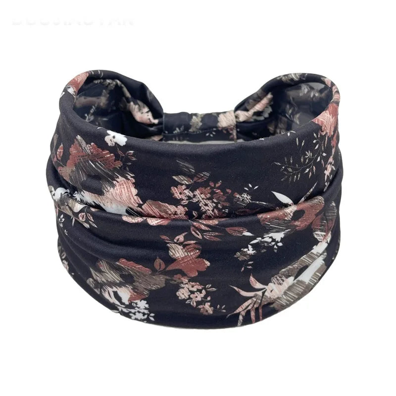 A black floral butterfly patterned fabric headband rolled into a coil.