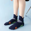 A pair of navy blue cycling and running socks with white stripes and orange accents worn on a person's legs.