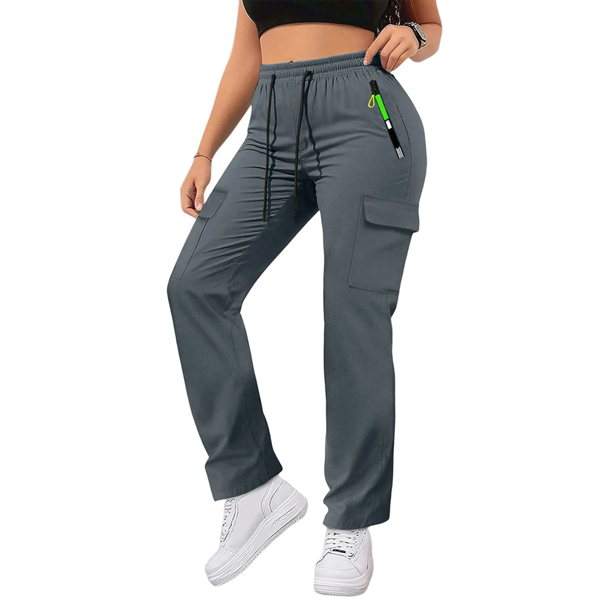 A woman wearing gray drawstring cargo pants and a black top, standing and looking down.