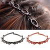 Un set de clips y diadema para el cabello con dos flecos, hechos de metal marrón oscuro y oro rosa.