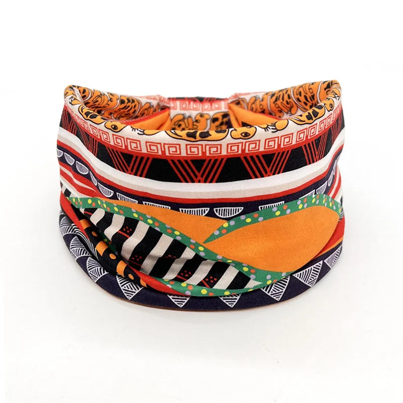 A colorful bohemian stretch cotton headband featuring various animal and geometric patterns in orange, black, and white.