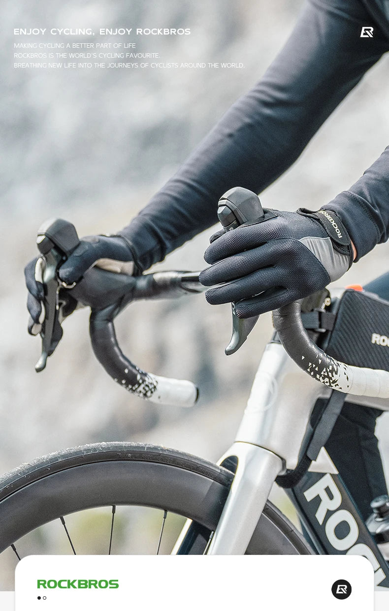 A close-up of a person wearing black cycling gloves gripping the handlebars of a bicycle.