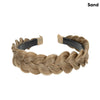 A gold blonde braided hair accessory worn around the wrist.