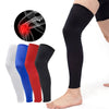 A collection of black, white, blue, and red knee calf compression sleeves shown next to a leg wearing a black sleeve.