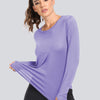 A woman models a purple loose fit sun protection t-shirt with black leggings.