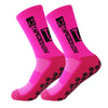 A pair of bright pink anti-slip performance sports socks shown from the side.