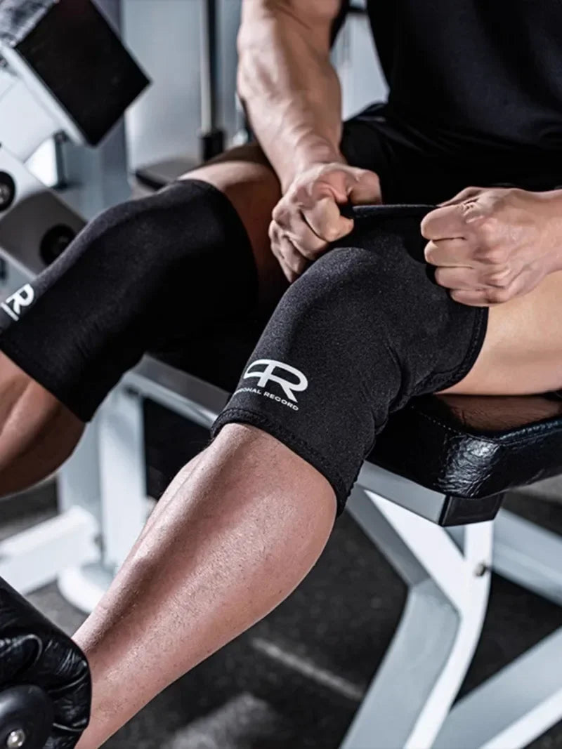 A person wearing black neoprene knee pads while exercising or lifting weights.